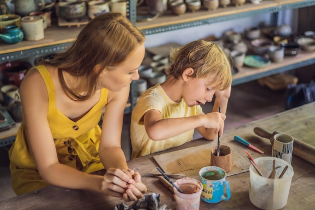 Mutter und Sohn machen Keramiktopf in der Töpferwerkstatt