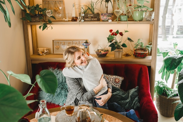 Mutter und Sohn mit Blumen im Kaffee. Sohn gibt der Mutter Blumen. süße Familie. Internationaler Frauentag, 8. März feiern