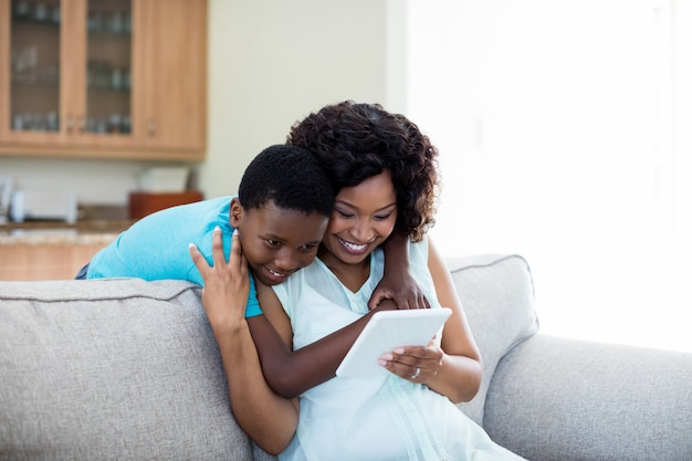 Mutter und Sohn mit digitaler Tablette im Wohnzimmer