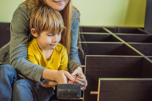 Mutter und Sohn montieren Möbel Junge hilft seiner Mutter zu Hause Happy Family Konzept