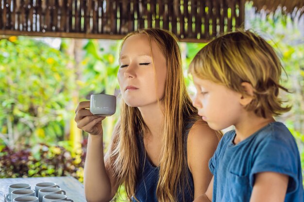 Mutter und Sohn probieren verschiedene Kaffee- und Teesorten, darunter Kaffee Luwak.