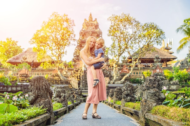 Mutter und Sohn Reisende im Hintergrund des Pura Taman Kemuda Saraswati Tempels in Ubud, Insel Bali, Indonesien Reisen mit Kindern Konzept mit Sonnenlicht