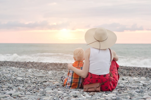 Mutter und Sohn sitzen am Strand