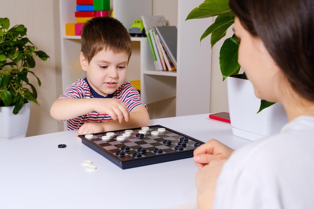 Mutter und Sohn spielen Dame im Haus