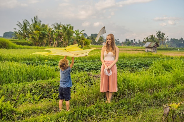 Mutter und Sohn starten einen Drachen in einem Reisfeld auf der Insel Ubud Bali Indonesien