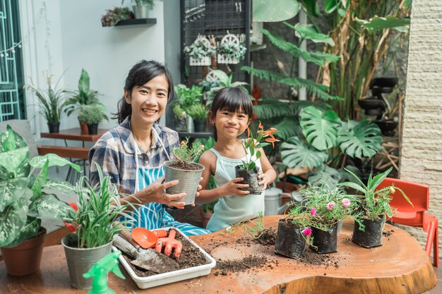 Mutter und Tochter arbeiten im Garten und pflanzen einige Pflanzen