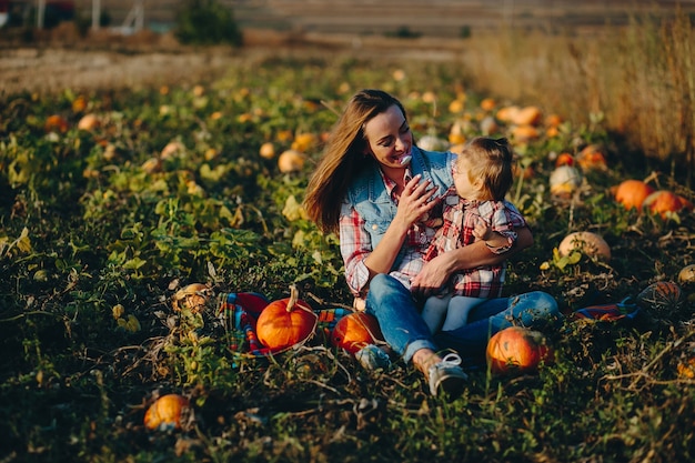 Mutter und Tochter auf einem Feld mit Kürbissen, Halloweenabend