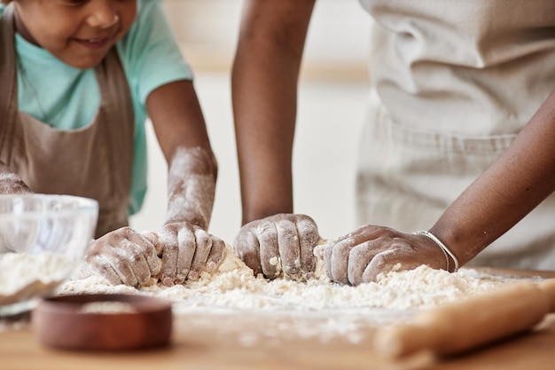 Mutter und Tochter backen zusammen in der Küche und kneten Teig