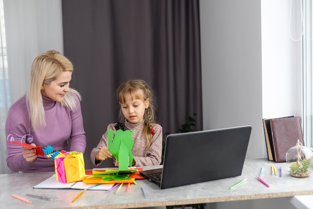 Mutter und Tochter basteln zusammen Papier