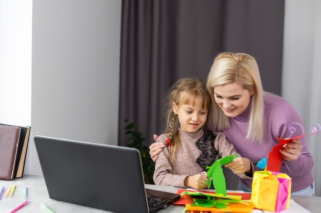 Mutter und Tochter basteln zusammen Papier