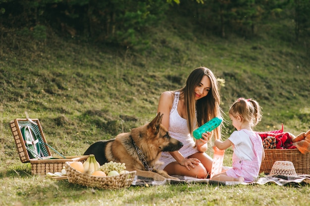 Mutter und Tochter bei einem Picknick mit einem Hund