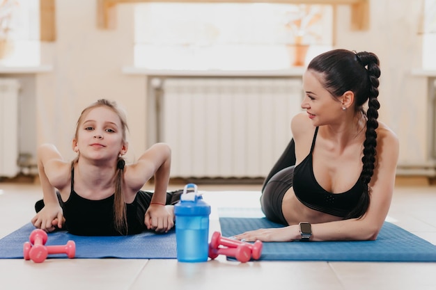 Mutter und Tochter beim Stretching im Fitnessstudio