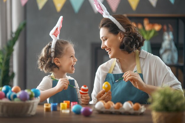 Mutter und Tochter bemalen Eier Glückliche Familie, die sich auf Ostern vorbereitet