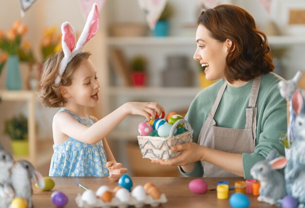 Mutter und Tochter bemalen Eier Glückliche Familie, die sich auf Ostern vorbereitet