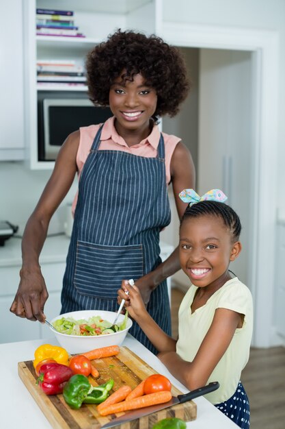 Mutter und Tochter bereiten Salat in der Küche zu Hause vor