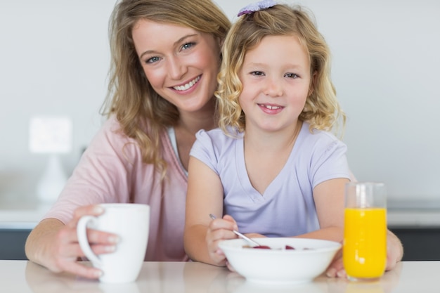 Mutter und Tochter, die bei Tisch frühstücken