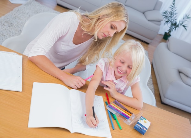 Mutter und Tochter, die bei Tisch zusammen zeichnen