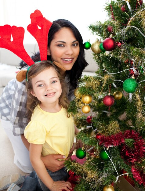 Mutter und Tochter, die einen Weihnachtsbaum verzieren