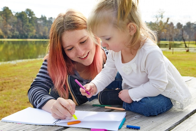 Mutter und Tochter, die Farben in einem Park zeichnen