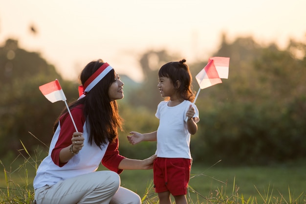 Mutter und Tochter, die Flagge von Indonesien hissen