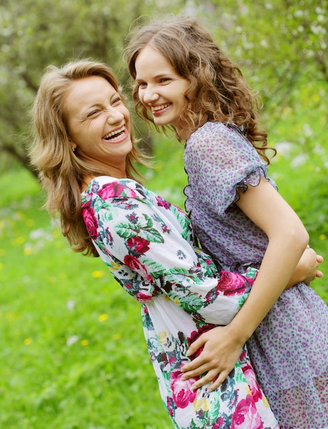 Mutter und Tochter, die im Park umarmen und lachen