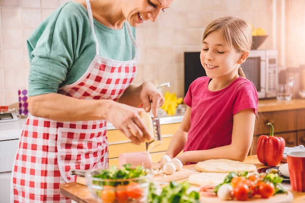 Mutter und Tochter, die Pizza zubereiten