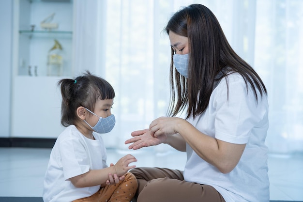 Mutter und Tochter, die Sanitizer-Handgelreiniger gegen Bakterien verwenden, verhindern das COVID19-Virus