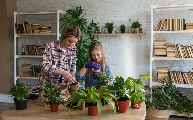 Foto mutter und tochter, die zu hause pflanzen neu pflanzen, nahaufnahme