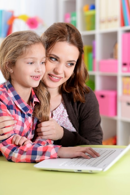 Mutter und Tochter, die zusammen Laptop verwenden