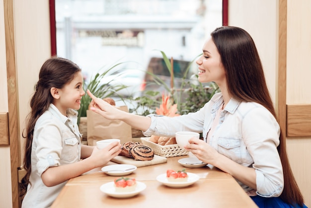 Mutter und Tochter essen im Kaffee.