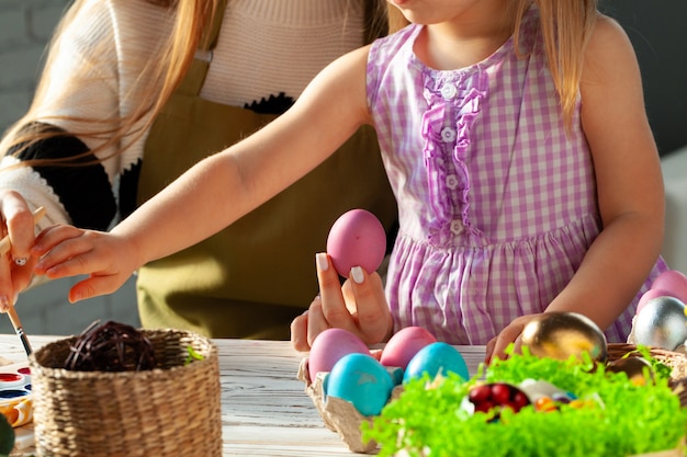 Mutter und Tochter färben Eier für Ostern