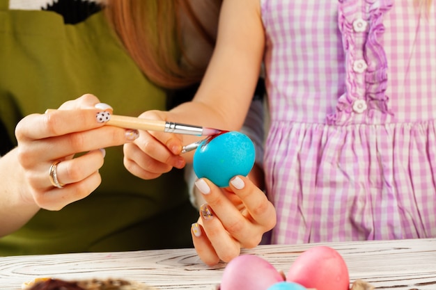 Mutter und Tochter färben Eier für Ostern