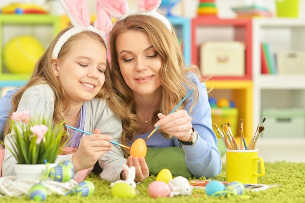 Mutter und Tochter färben Eier zu Ostern