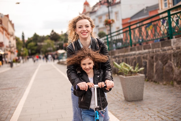 Mutter und Tochter fahren Roller und haben eine tolle Zeit