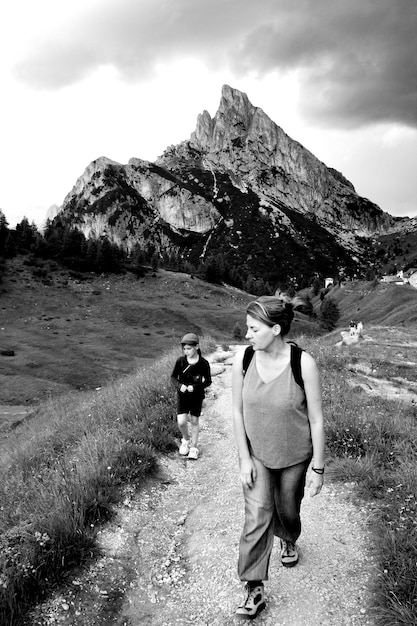 Foto mutter und tochter gehen auf einem fußweg gegen die berge