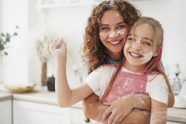 Mutter und Tochter haben Spaß beim Kochen von Teig in der Küche