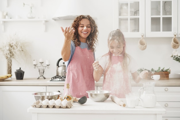 Mutter und Tochter haben Spaß beim Kochen von Teig in der Küche