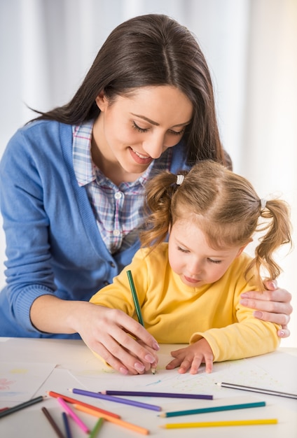 Mutter und Tochter haben Spaß beim zu Hause zeichnen.