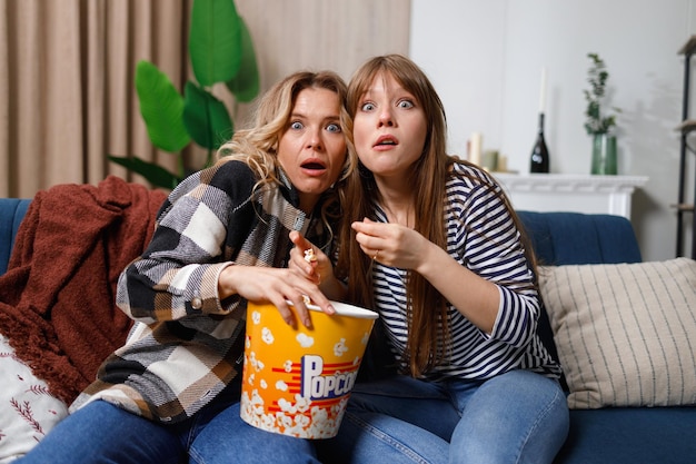 Mutter und Tochter haben Spaß daran, ihre Freizeit zu Hause gemeinsam zu verbringen und sich einen Gruselfilm anzusehen