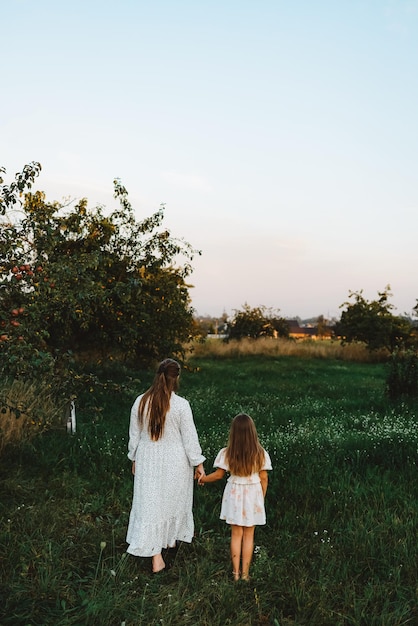 Mutter und Tochter halten Händchen und schauen nach vorne