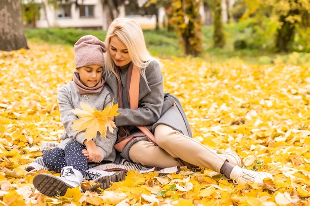 Mutter und Tochter im gelben Herbstpark.