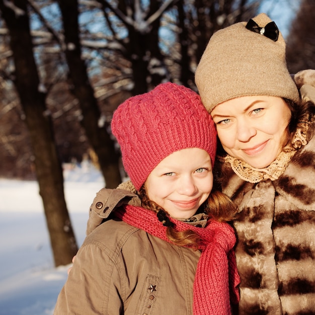 Mutter und Tochter im sonnigen Wintertag im Freien