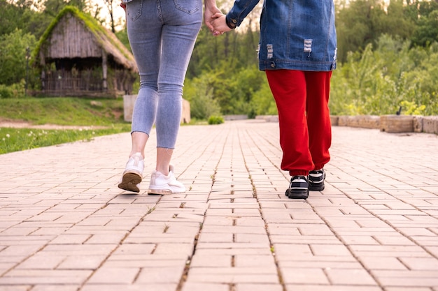 Mutter und Tochter im Teenageralter, die in einem Park spazieren gehen, eine Frau und ein Mädchen im Teenageralter, die in einer Stadt herumhängen, Lifestyle-Familie