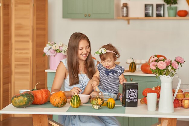 Mutter und Tochter in der Küche mit Thanksgiving-Dekorationen