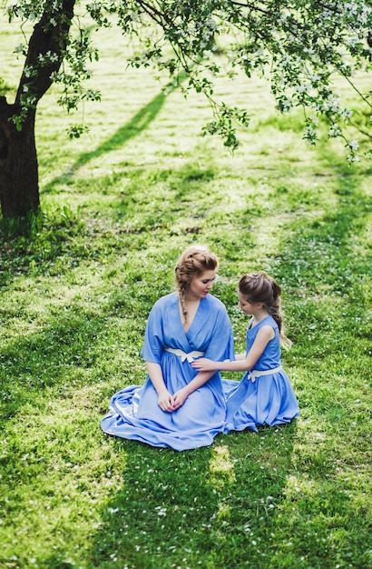 Mutter und Tochter in Kleidern in der Natur