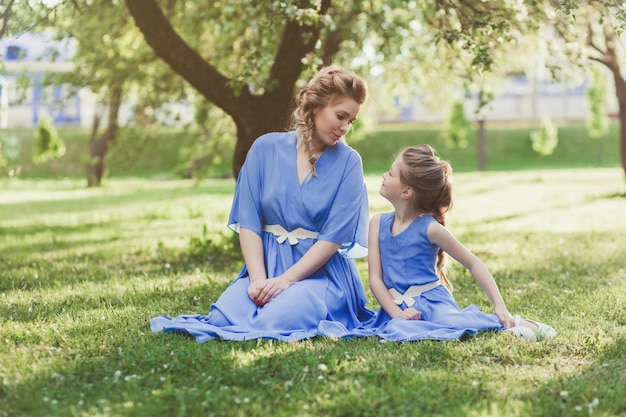 Mutter und Tochter in Kleidern in der Natur