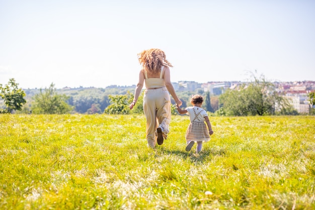 Mutter und Tochter lachen und haben Spaß im Park das Konzept einer glücklichen Familienfreundschaft und Liebe