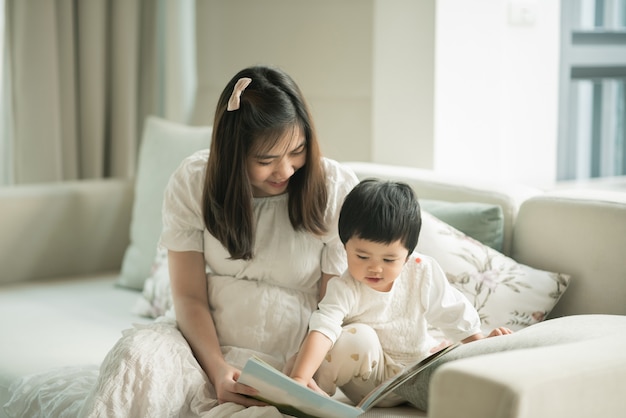 Mutter und Tochter lesen im Wohnzimmer ein Buch