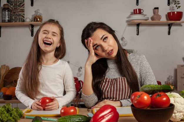 Mutter und Tochter machen einen Gemüsesalat und haben Spaß in der Küche.