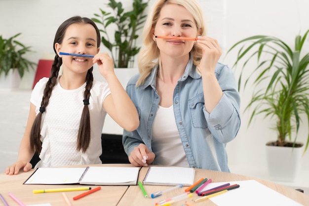 Mutter und Tochter machen gemeinsam Hausaufgaben.